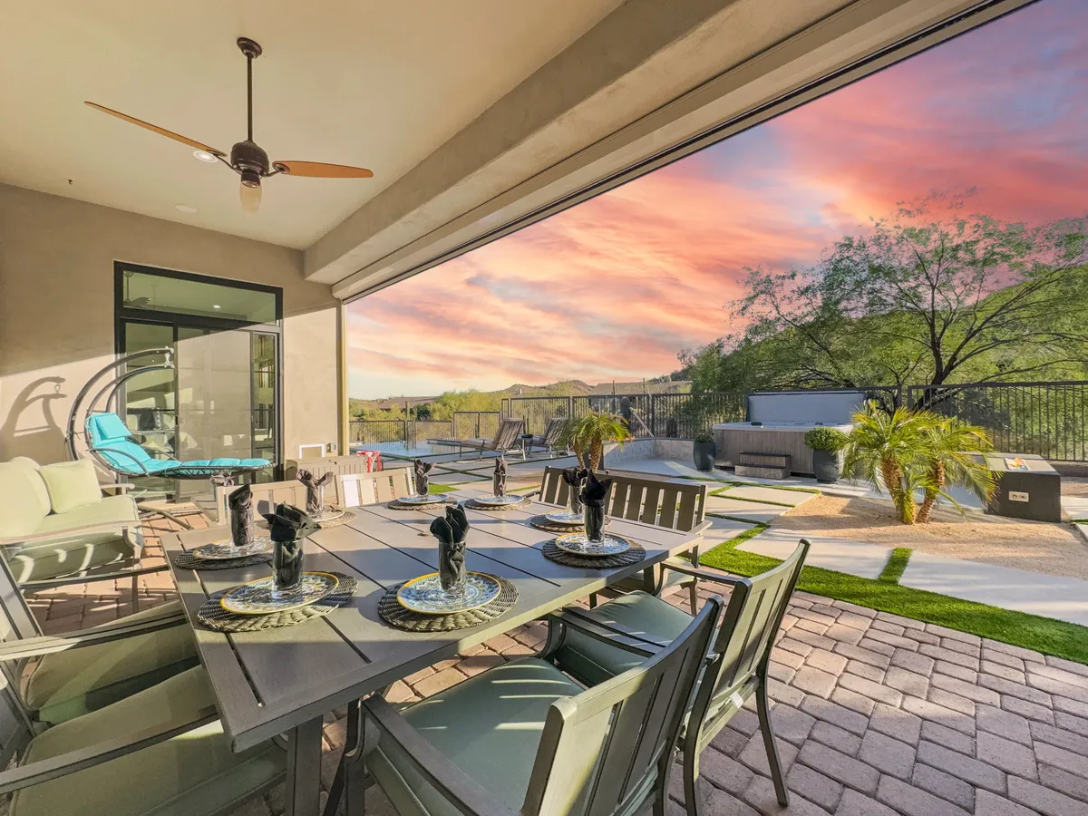 An open-air patio dining area set with place settings, offering expansive panoramic views of the surrounding landscape beyond the patio. Comfortable seating and a relaxed ambiance make this an ideal spot for outdoor meals or social gatherings while soaking in the scenery.